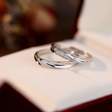 Macro detail of elegant silver heart rings with pavé diamonds on a beige cushion