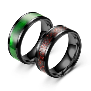 Close-up of black stainless steel rings featuring green marble and red dragon inlays.