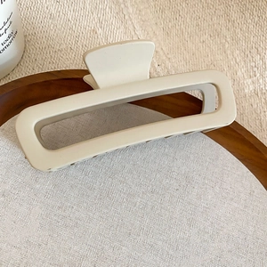Primo piano della pinza per capelli opaca bianco crema con design rettangolare scavato