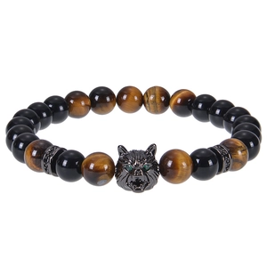 Macro detail of 8mm tiger eye beads and metal wolf head with green cubic zirconia eyes