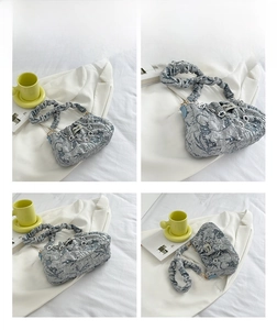 Detail view of light blue ruched cloud bag with jacquard texture and floral chain