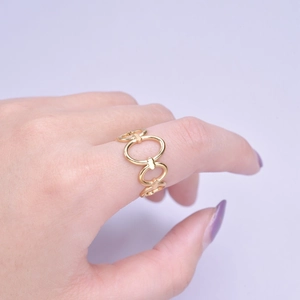 Close-up of golden hollow chain link ring worn on finger in a minimalist style
