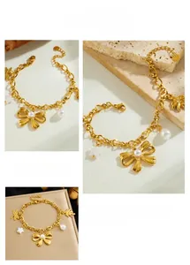 Detail view of gold charm bracelet with pearl bow, starfish, and flower pendants