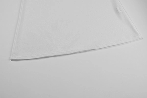 Dettaglio dell'orlo in maglia bianca con doppia cucitura ed etichetta tessuta laterale