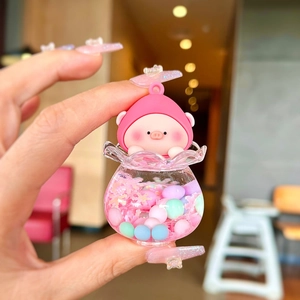 Close-up of pink pig liquid quicksand keychain with colorful balls and snowflakes