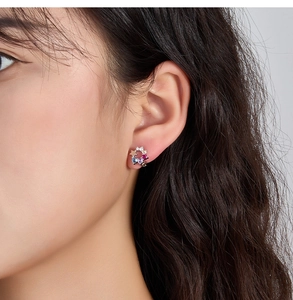 Detailed view of silver hoop earrings with colorful cubic zirconia and star charm