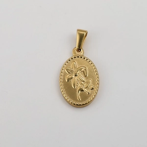 Macro detail of oval gold stainless steel pendant featuring embossed floral design elements