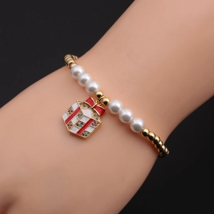 Détail d'un bracelet en perles avec un pendentif boîte cadeau rouge et blanc au poignet