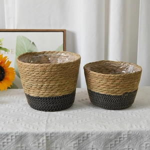 Set of two woven seagrass planters in natural and black bicolor design on a checkered cloth