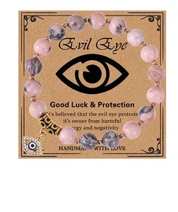 Macro view of 8mm pink zebra stone beads and crystal-encrusted Evil Eye charm on bracelet
