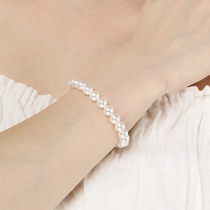 Close-up van een elegante witte parelarmband om de pols met ronde parels van 5/8mm