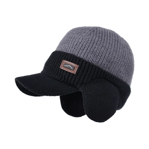 Winter knit baseball cap with ear flaps and mountain patch on a white background