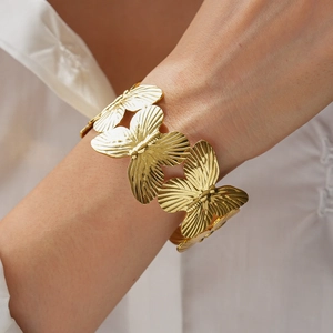 Detailed view of golden butterfly cuff bracelet with delicate metallic wing textures