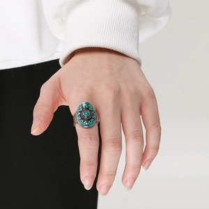 Detail of vintage bohemian silver ring with turquoise oval face worn on a model's finger