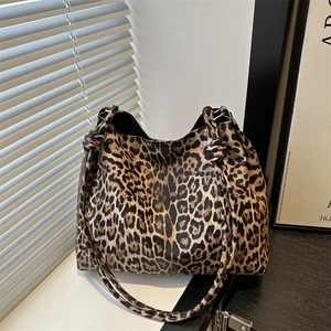 Leopard print tote bag with knotted strap shown in elegant interior lighting