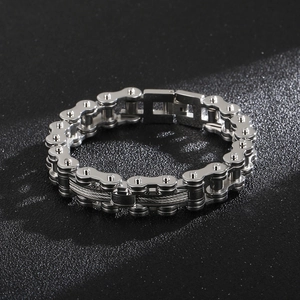 Detail of silver stainless steel motorcycle chain bracelet with central cable inlay