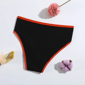 Detailed macro view of black ribbed cotton panties with red trim on white background