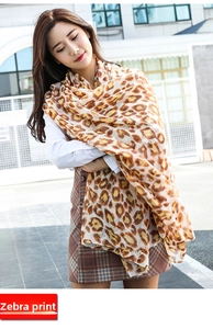Detailed view of the lightweight leopard print silk scarf on a model outdoors