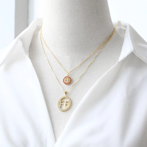 Gold plated pendant necklaces featuring FE letter charms with red and white cubic zirconia