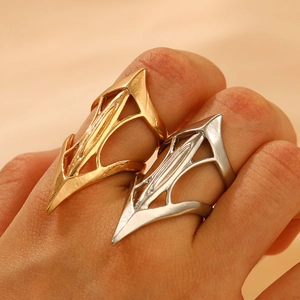 Close-up of gold and silver gothic hollow geometric rings on fingers in punk style