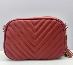 Dettaglio borsa fotografica rossa trapuntata in ecopelle con catena dorata e nappa