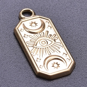 Macro detail of gold evil eye pendant featuring engraved moon and star patterns