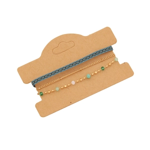 Three-piece Bohemian bracelet set with woven blue ribbon and gold beaded chains on a card