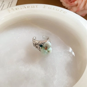 Macro detail of vintage silver textured open ring with light green shell flower petals