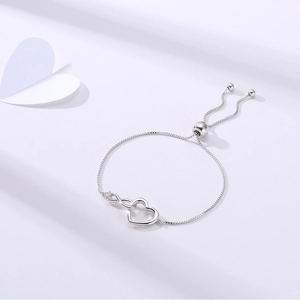 Detailed close-up of silver infinity heart bracelet with adjustable chain and zircon stones