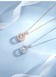 Detailed view of silver and rose gold daisy pendants with central stones and crystals