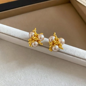 Macro detail of French vintage gold flower earrings with three clustered pearls