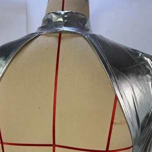 Détail de la robe argentée métallisée avec dos nu et finition brillante miroir