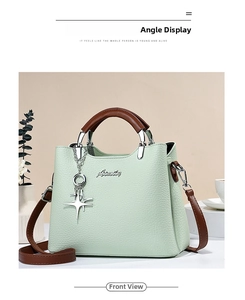 Front view of light green lychee pattern handbag with brown handles and star charm