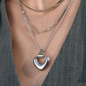 Three-layer silver necklace with a large heart pendant and twisted rope chain style