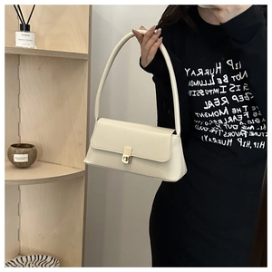 Detail view of cream PU leather shoulder bag with elegant gold metal clasp and single strap