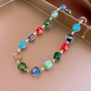 Close-up of vintage multi-color glass bead necklace on a rose gold display tray