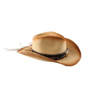 Close-up of woven straw cowboy hat with ethnic band and metal bull head pendant