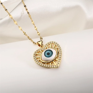 Macro detail of heart-shaped evil eye pendant with blue resin and zircon inlay