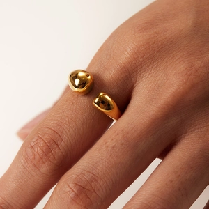 Detailed view of polished gold teardrop open ring worn on a woman's finger