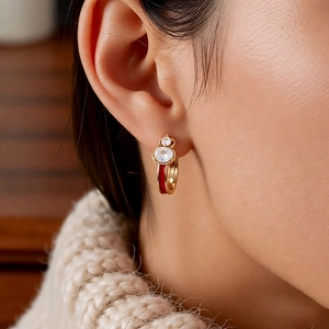 Detail shot of elegant red enamel gourd earrings with cubic zirconia on a model