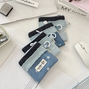 Detail der Denim-Geldbörse mit Sterndruck, Fransen und weißem Aufhängering-Verschluss