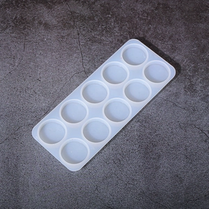 Detail of 10-cavity round silicone mold for DIY crafts on grey stone background