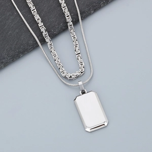 Detail of silver double-layered necklace featuring Byzantine chain and rectangular tag