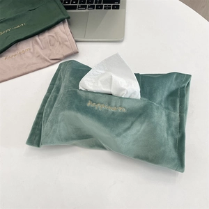 Detail of embroidered velvet tissue box covers in green and pink with happiness text