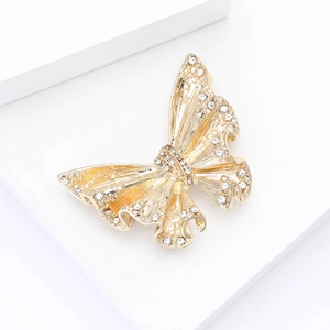 Detailed macro of golden alloy butterfly brooch with sparkling inlaid rhinestones