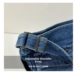 Close-up of adjustable strap with black buckle on a dark blue denim crossbody bag