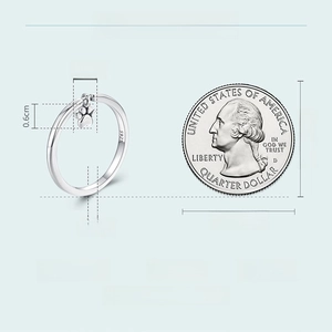 Size comparison of 925 sterling silver puppy paw ring next to a quarter coin