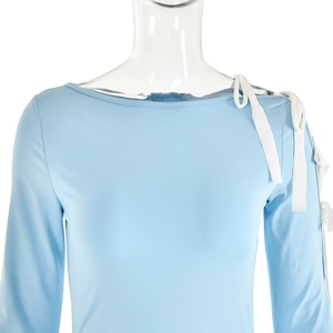 Detail view of light blue off-shoulder dress featuring white lace-up tie shoulder design