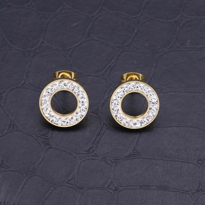 Golden hollow round stud earrings with sparkling crystals on black leather background