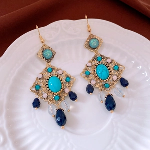 Détail de boucles d'oreilles vintage en cristal losange avec pierres émeraude